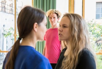 Performance, "I want to say something", Participants: Tobias Bienz, Denise Hasler and Martina-Sofie Wildberger, April 5, 2018, Rome Group of three in a bright room, two with backs turned, engaged in conversation.