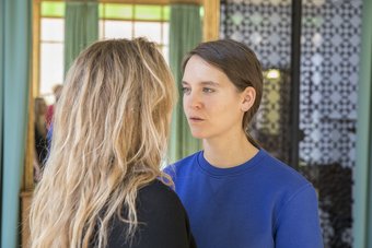 Performance, "I want to say something", Performer: Denise Hasler and Martina-Sofie Wildberger, April 5, 2018, Rome Two people standing face-to-face in a room with patterned wall and green curtains.